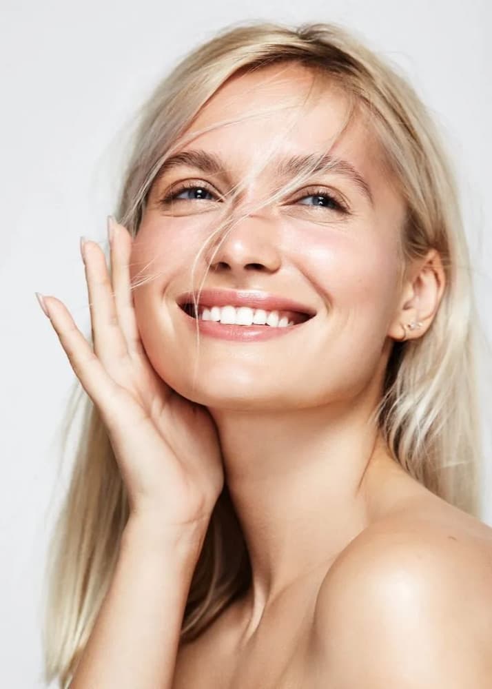 Portrait of a woman with clear, relaxed skin in soft natural light
